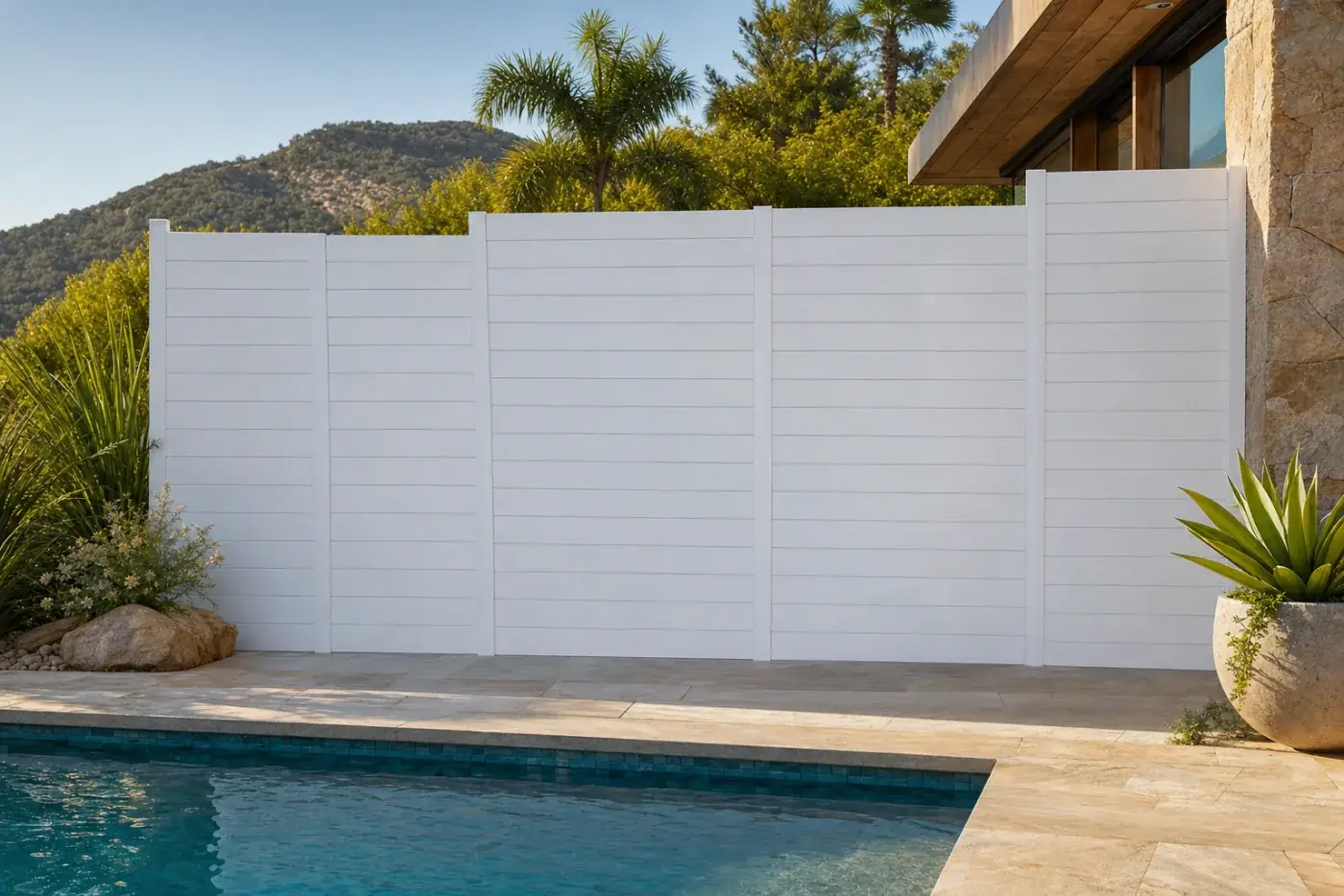 Tanca de lamel·la opaca blanca al voltant d'una piscina de disseny amb terrassa de pedra